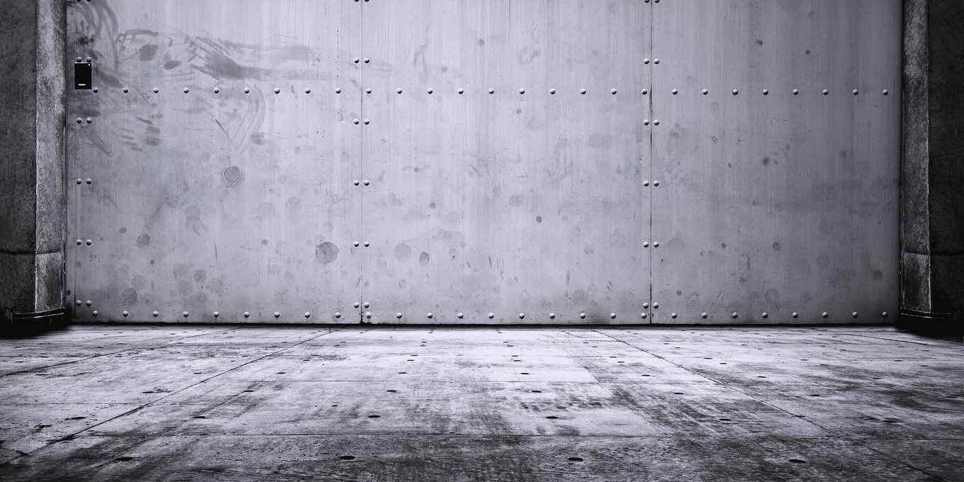 A bare concrete wall and floor in an empty room