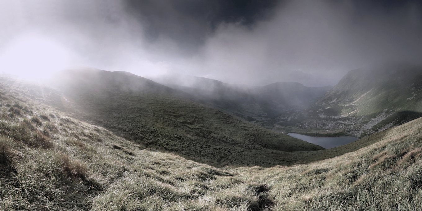 Cloud breaking over a high green valley